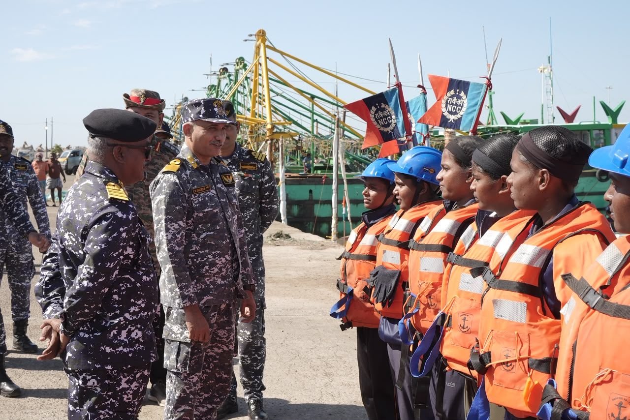 Officer addressing dignitaries beneath the Kadalakku Povom · Project SWARNUM banner at the flagging-off ceremony