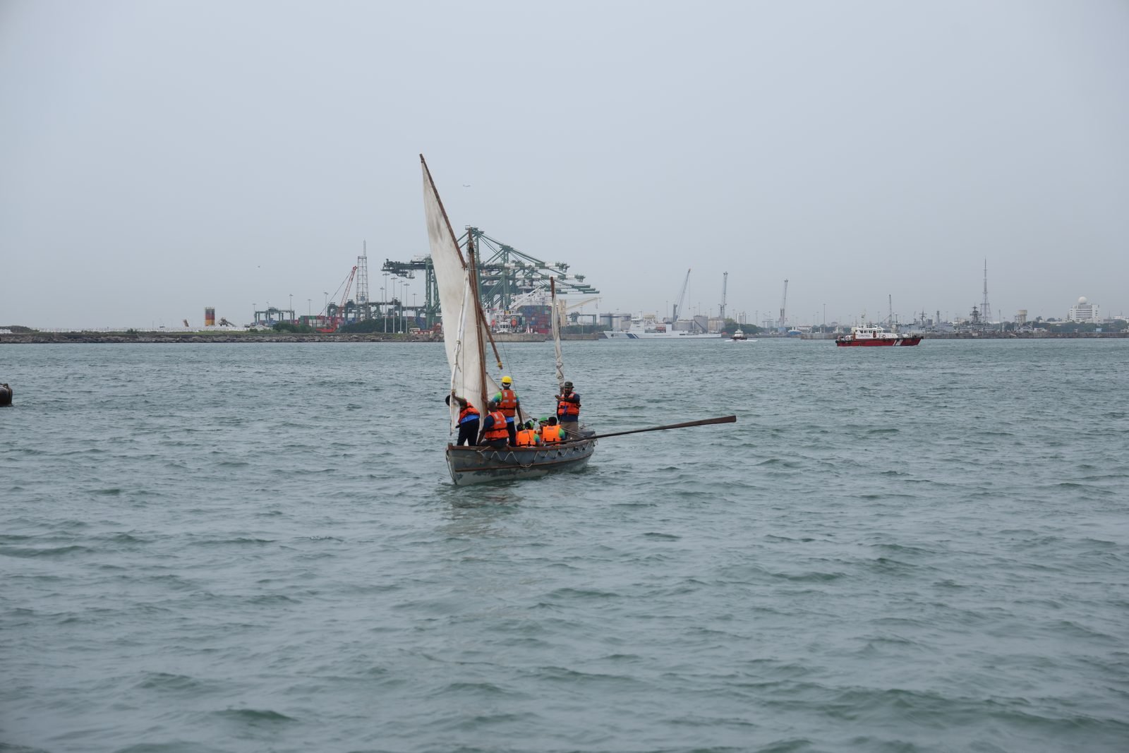 Whaler sailing towards Chennai with the port cranes behind