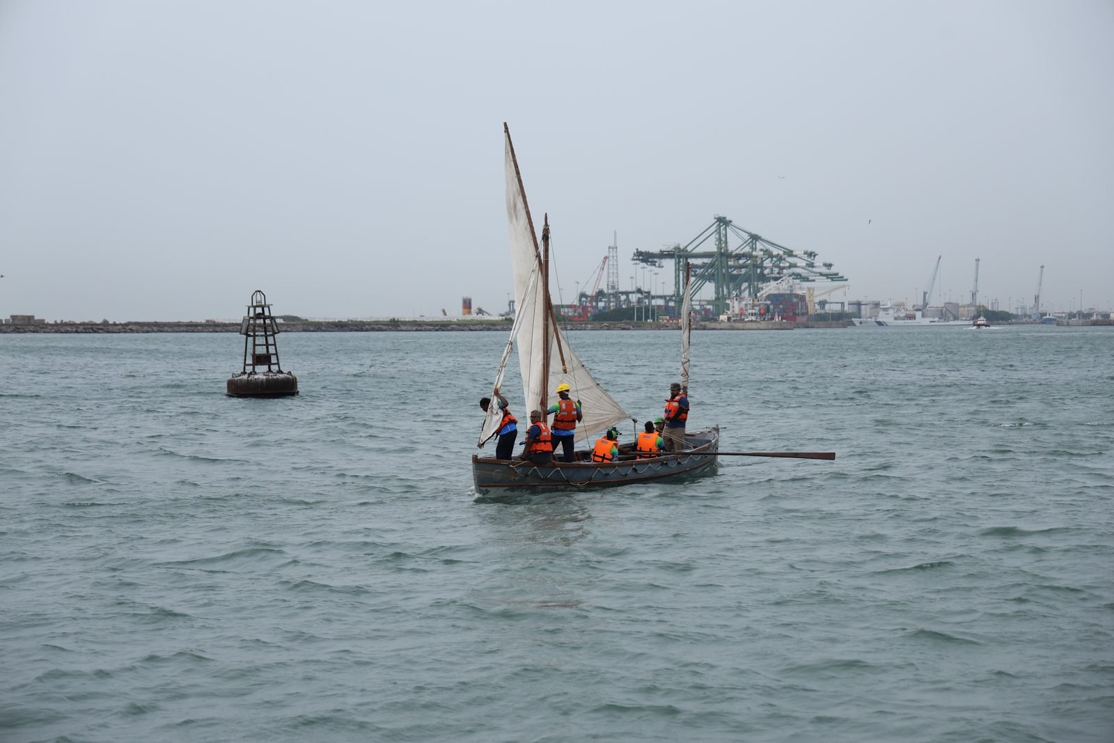 Whaler and crew nearing the Chennai shoreline past a channel marker