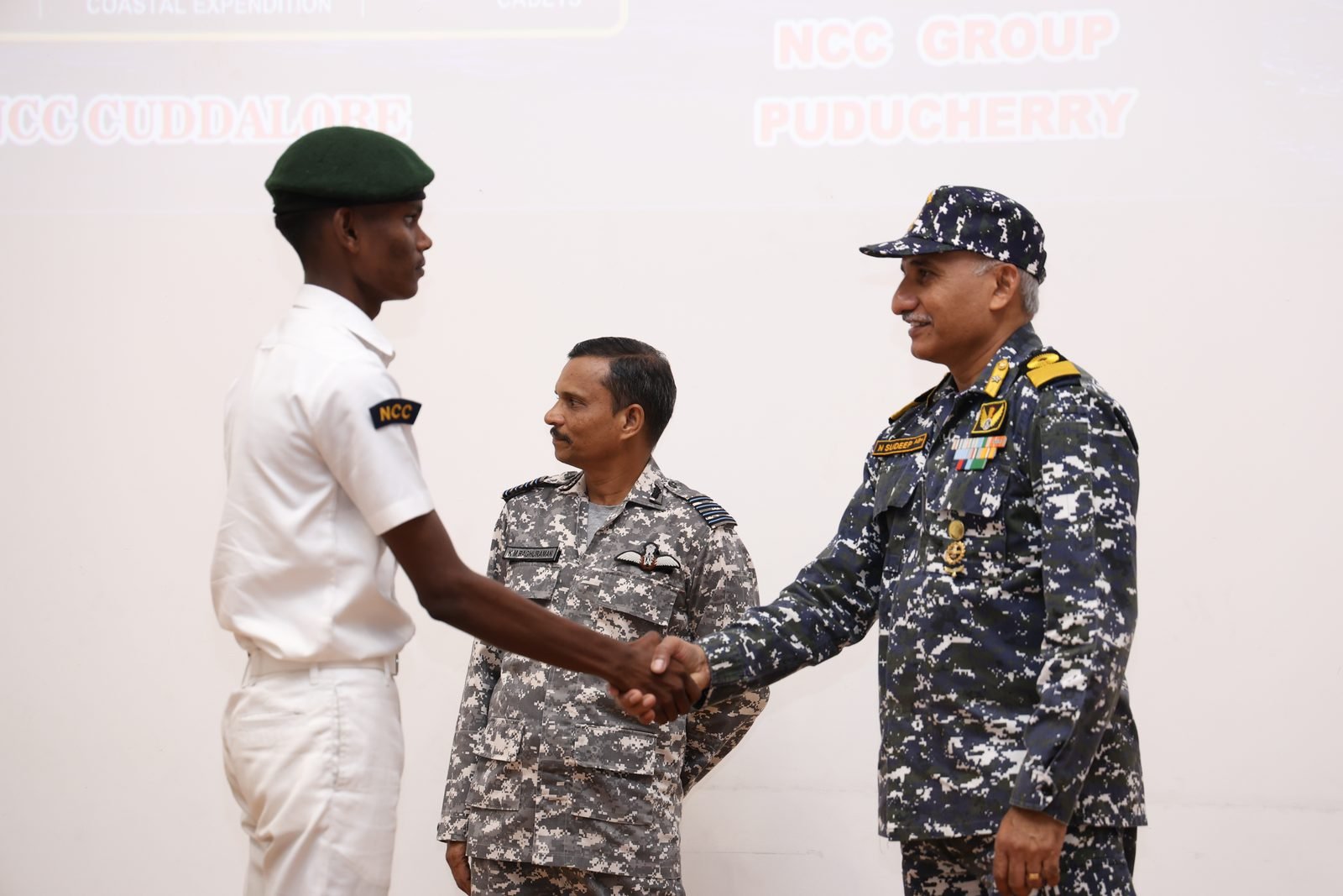 Cadet receiving a certificate with a handshake from the reviewing officer