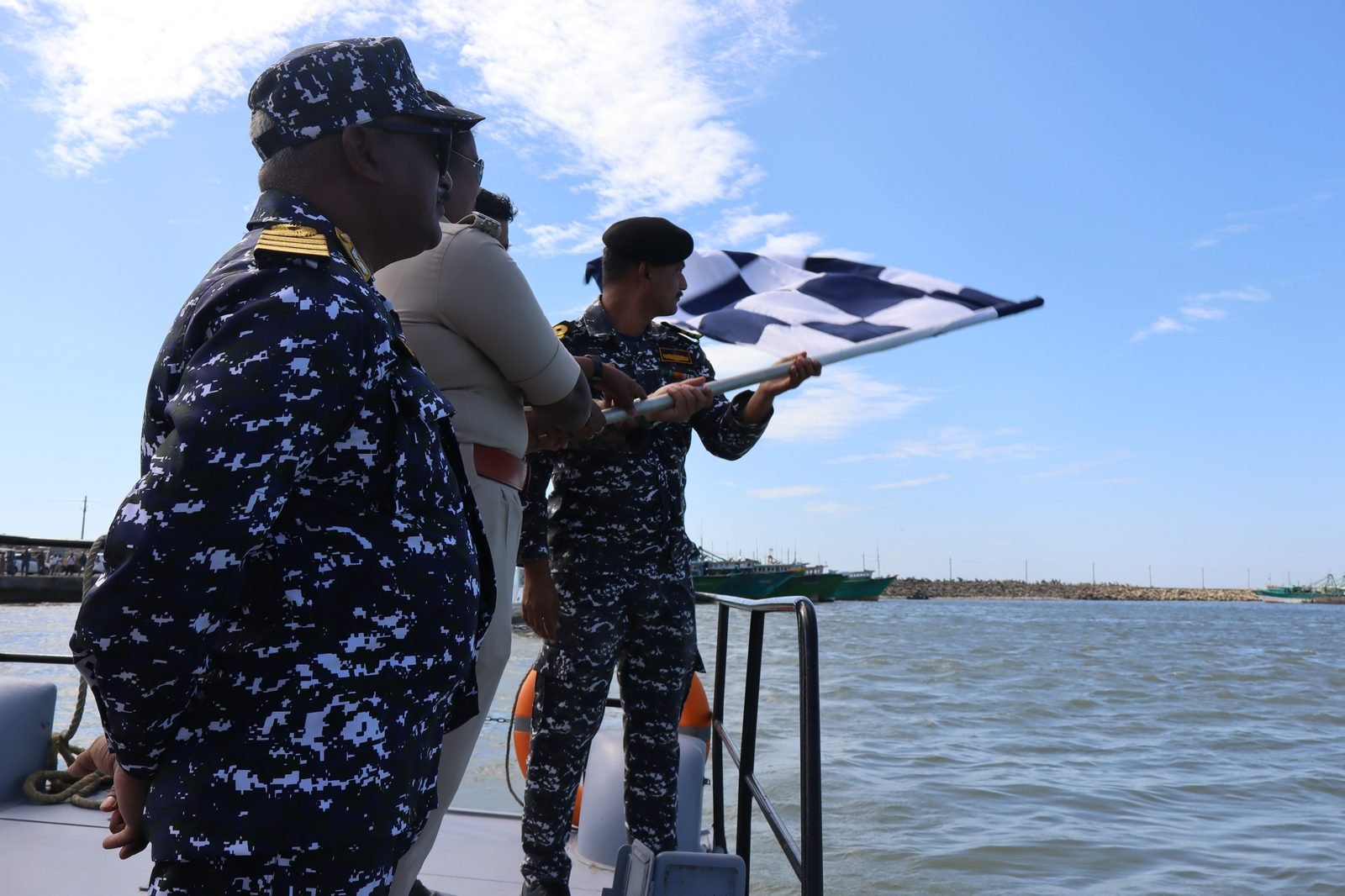 Officers waving checkered flag from Indian Coast Guard vessel