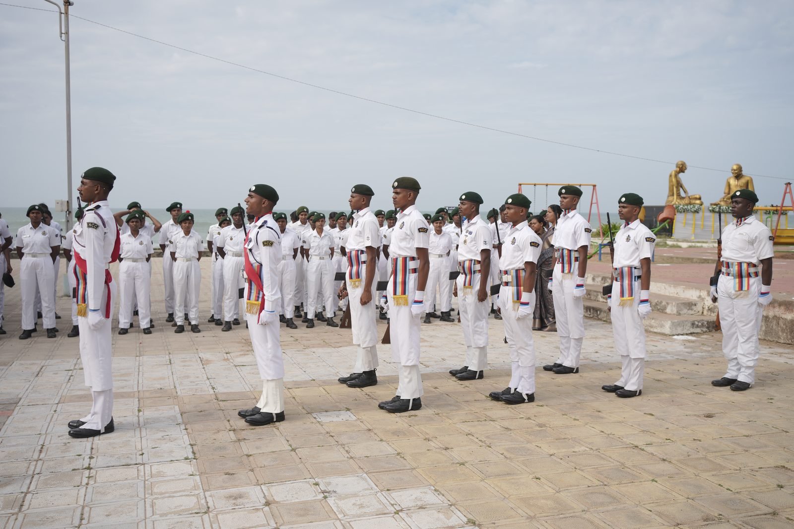 NCC cadets in ceremonial whites with rifles in parade formation at Gandhi Mandapam