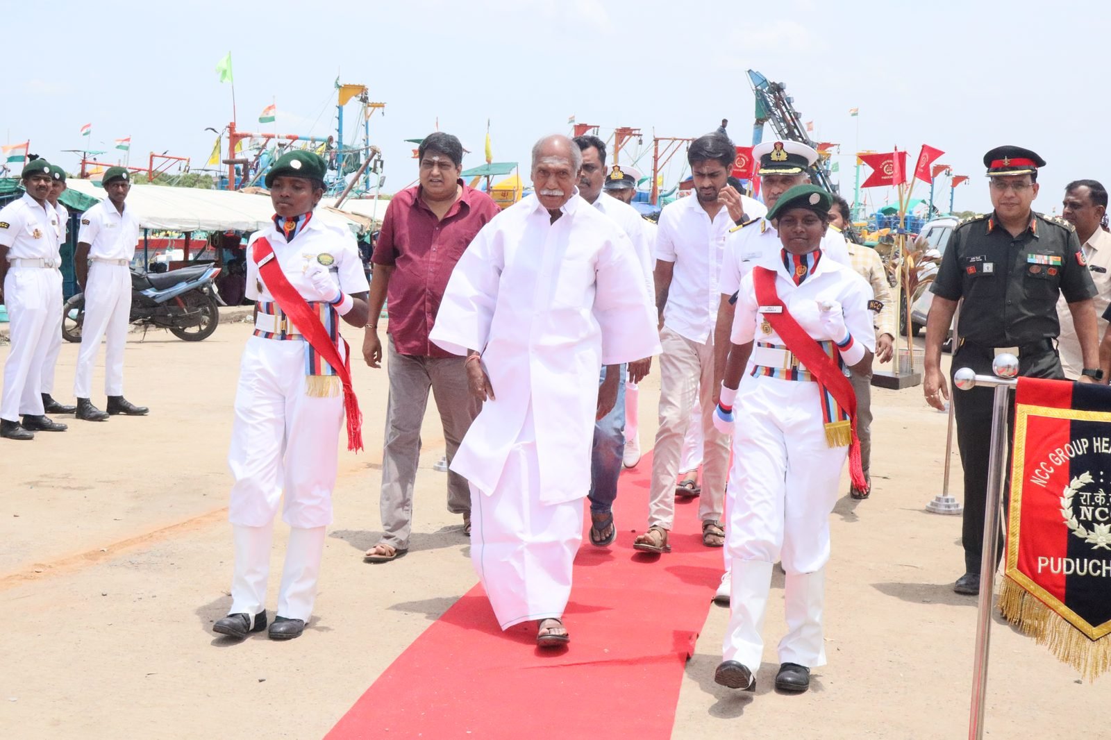 Chief Minister escorted by NCC cadets in white ceremonial uniform on red carpet