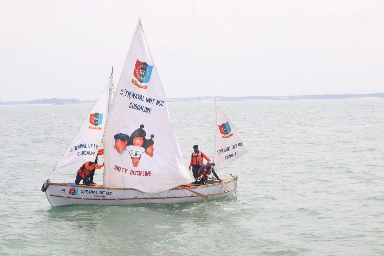 NCC whaler under sail displaying Unity Discipline motto