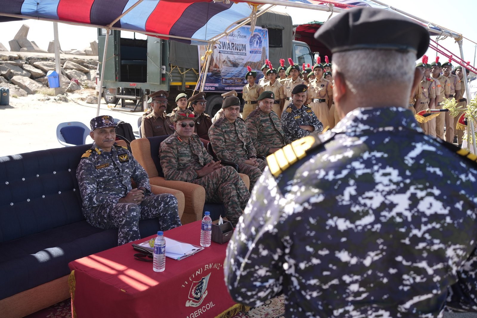 Officers seated at the Rameswaram fishing base briefing beneath the Project SWARNUM banner, cadets standing to attention