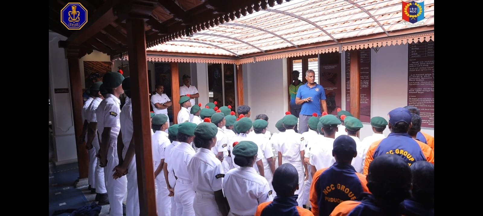 NCC cadets being addressed by a guide at a heritage building, NCC Group Puducherry banner visible